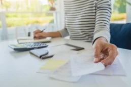 midsection businesswoman checking bill desk office